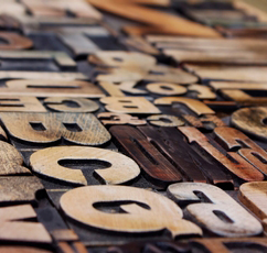 An array of typeface letters, in brown and grey tones.