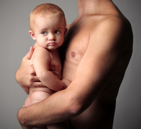 Torso of a nude man, from neck to waist, holding a nude baby.