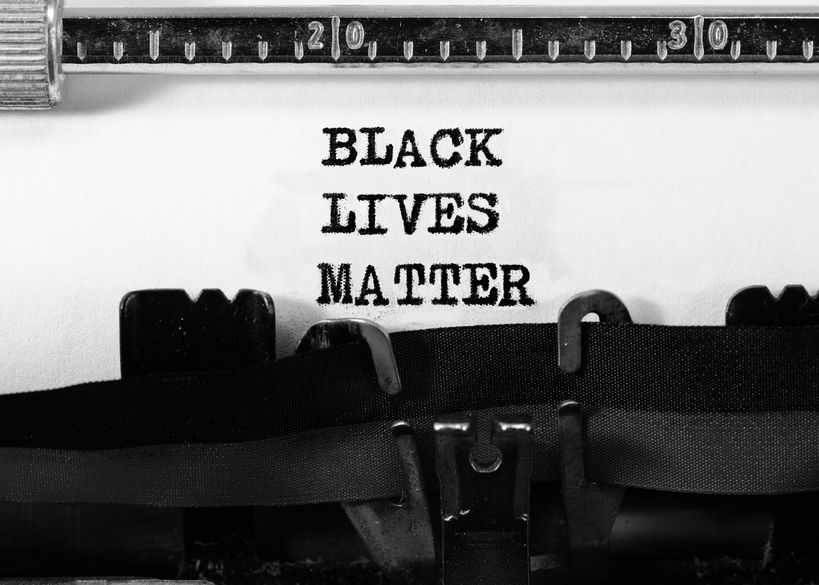 text BLACK LIVES MATTER on white background typed on a typewriter in a stark black-and-white image