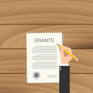 Person holding a pencil over a page titled “Grants.” (Copyright: binaryproject © 123RF.com)